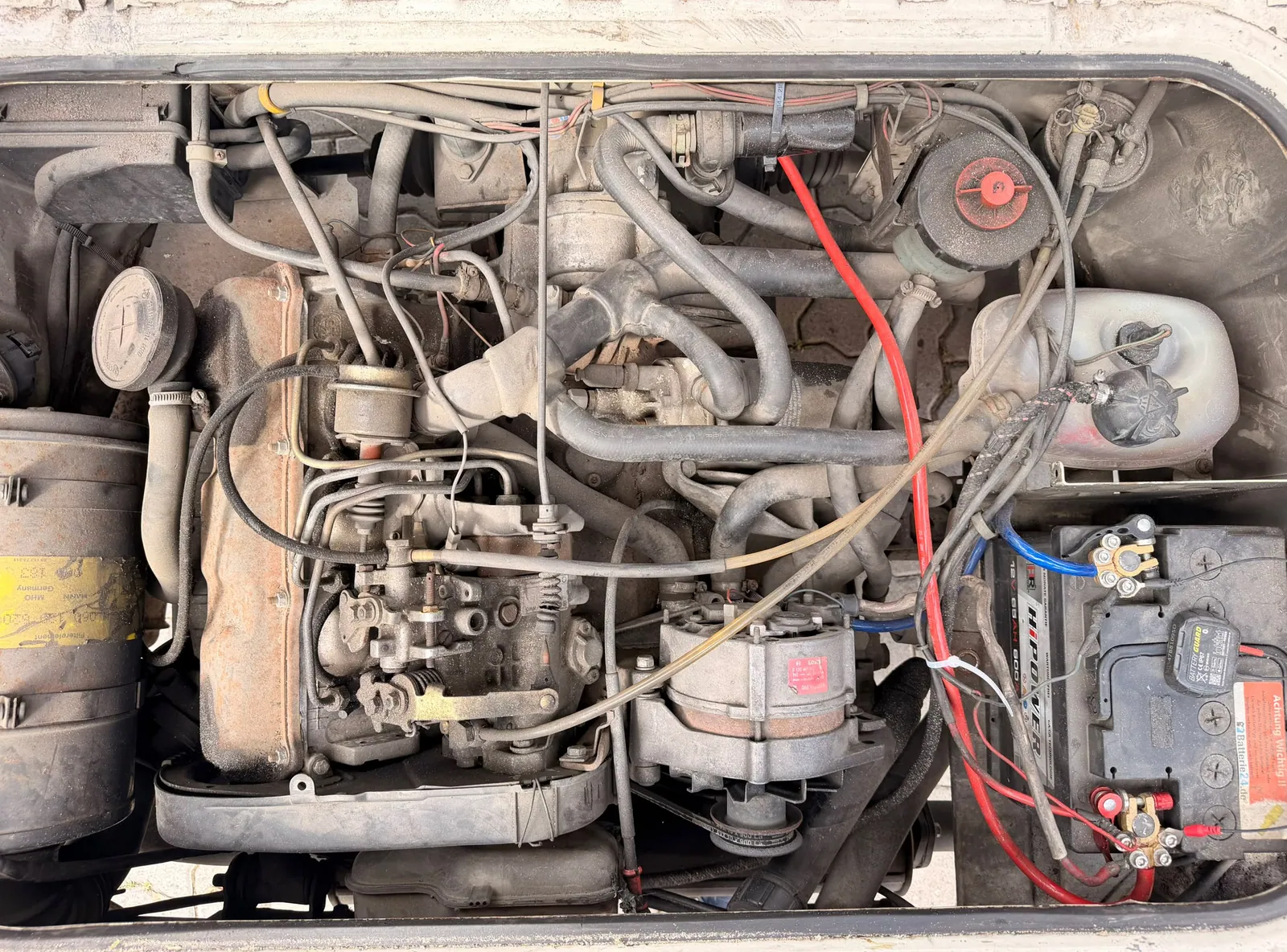 Motorraum eines Klassikers mit Staub, Ölfilm und Ablagerungen vor der Motorwäsche mit Trockeneis in München